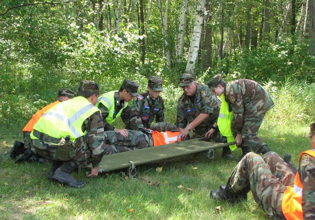 Military personnel conducting a rescue operation outdoors.