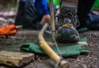 Person creating fire with bow drill technique.