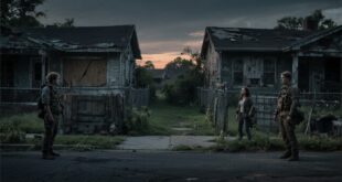 “Post-collapse suburban neighborhood with fences and wary neighbors showing the breakdown of trust in survival scenarios.”