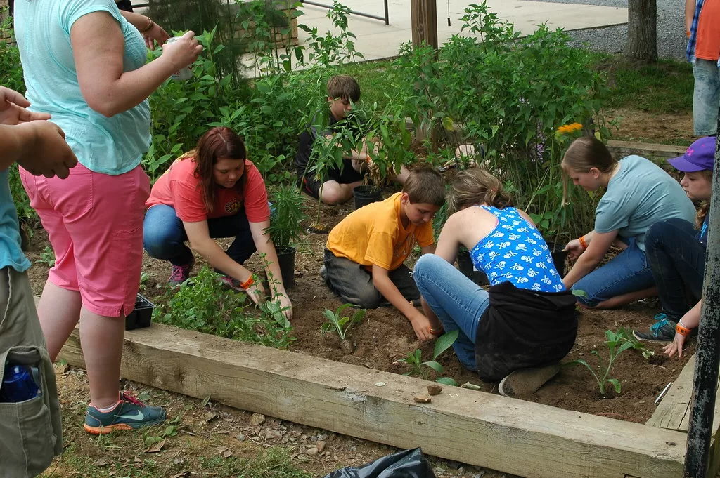 Group of children planting in a community garden.